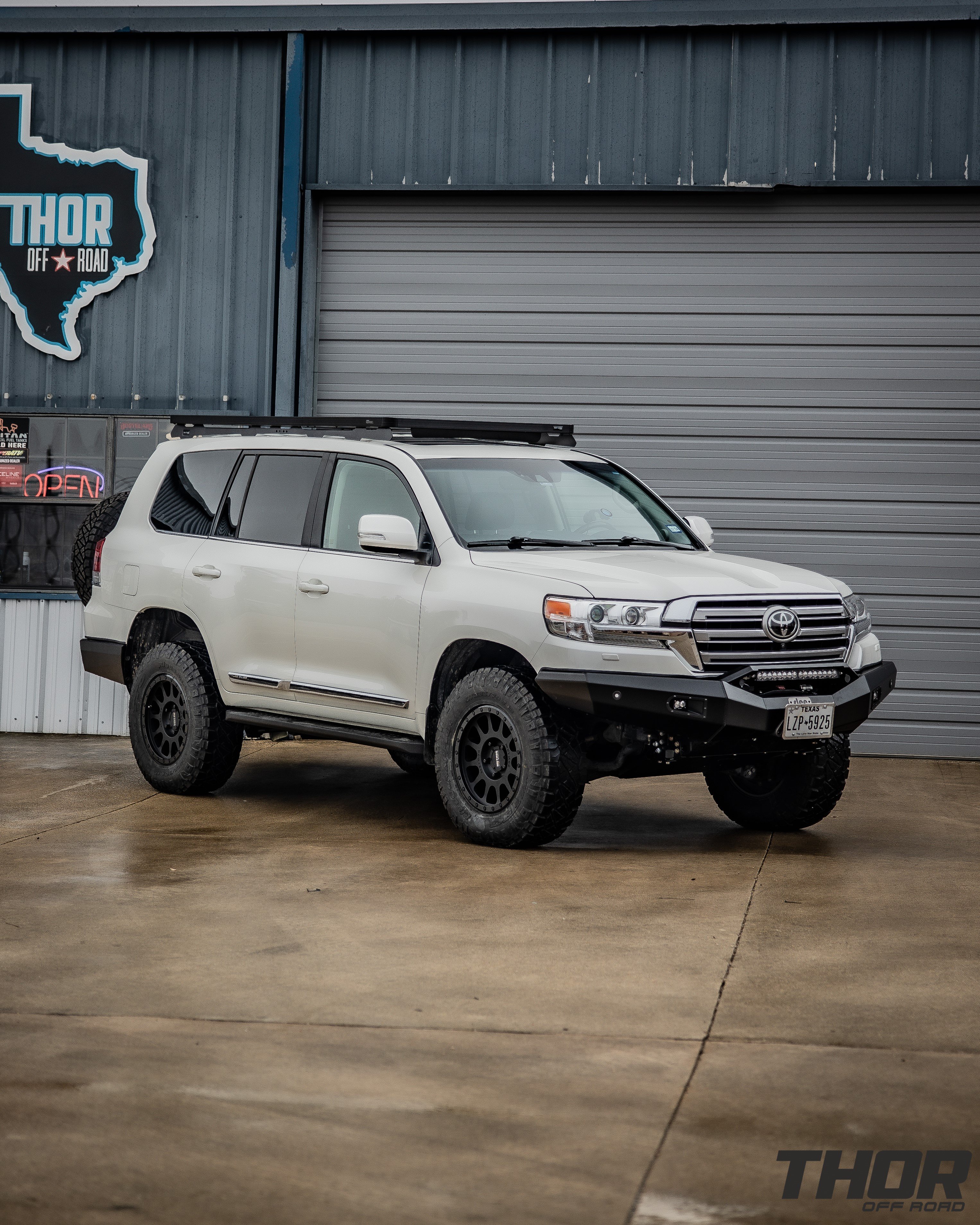 2021 Toyota Land Cruiser in Silver with OME BP-51 Suspension Kit, Method 305 18x9" +25 Wheels, Nitto Ridge Grappler 285/70R18 Tires, Slee Off-Road Front Bumper, Baja Designs S2 Driving Lights, Baja Designs S8 20" Combo Light Bar, Warn Zeon 12S Winch, Slee Off-Road Rear Bumper with Tire Carrier and Roof Rack, Long Range America 40 Gallon Auxillary Fuel Tank, Slee Off-Road Rock Sliders, Front Runner Slimline II Roof Rack Kit. Slee Off-Road Skid Plate System, Slee Off-Road Second Battery System, ARB Twin Compressor Kit