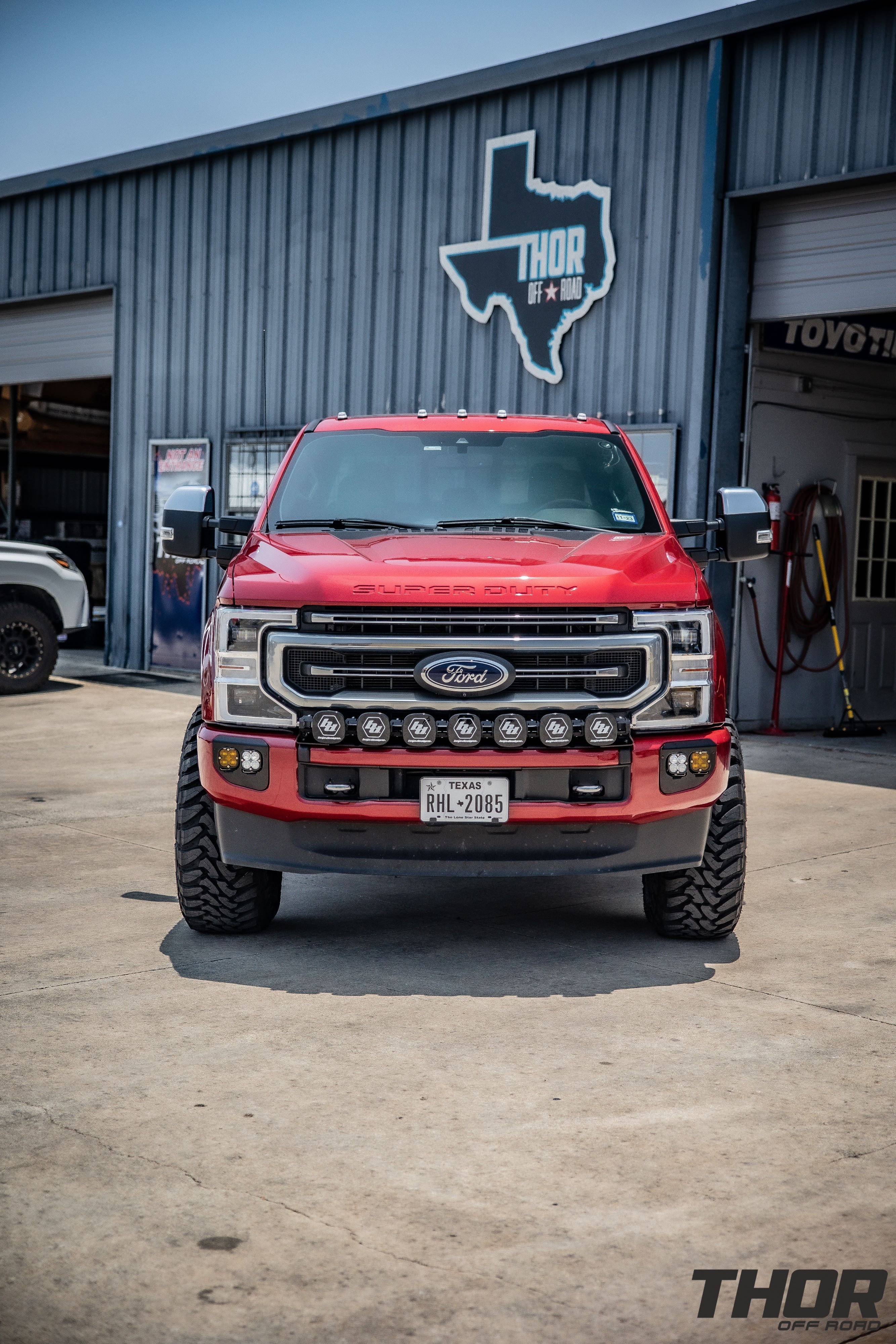 2022 Ford F-250 Super Duty Platinum in Red with Carli Backcountry 3.5" Suspension Kit, Carli 3.5" Fabricated Radius Arms, Carli 3.5" Full Rear Spring Replacement, Carli High Mount Steering Stabilizer, Carli Low Mount Steering Stabilizer, Carli Torsion Sway Bar, Method Racing MR304 17" Machined Wheels, 37x13.50R17 Toyo Open Country Tires, Baja Design Linkable Light Kit, Baja Design Fog Light Pocket Kit, Baja Design S2 Flush Mount Lights, Banks Differential Cover, Banks Exhaust Kit