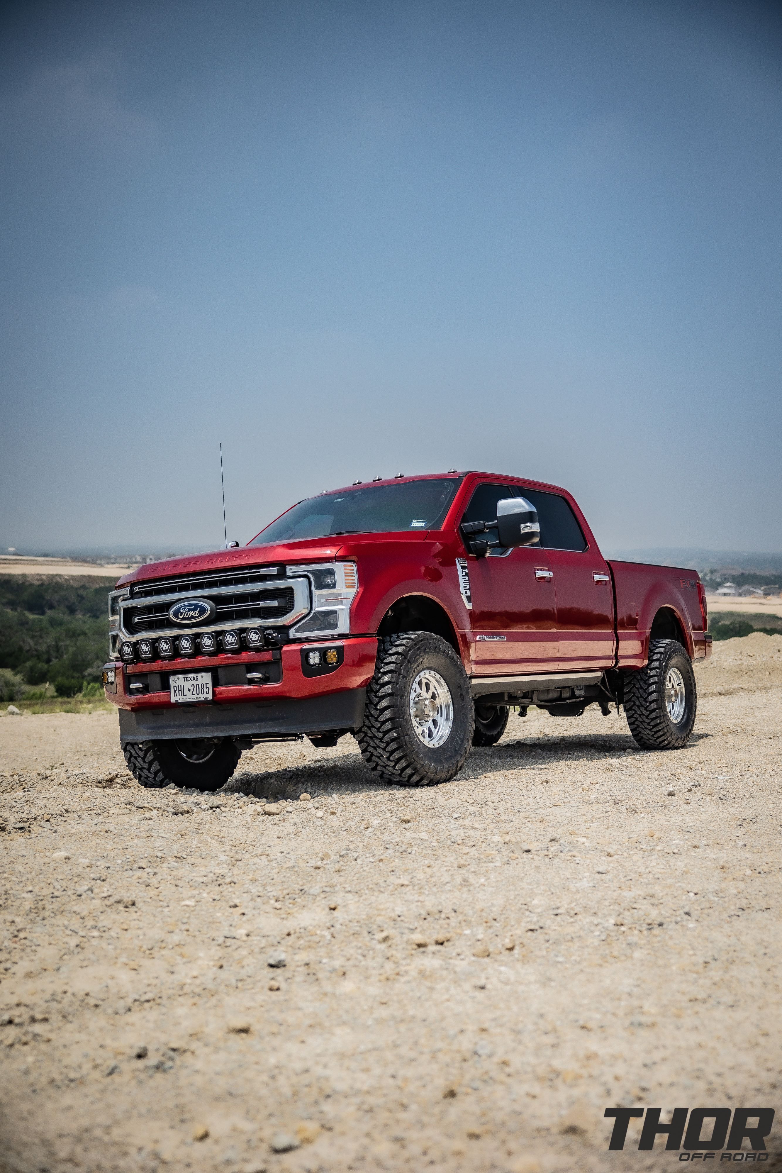 2022 Ford F-250 Super Duty Platinum in Red with Carli Backcountry 3.5" Suspension Kit, Carli 3.5" Fabricated Radius Arms, Carli 3.5" Full Rear Spring Replacement, Carli High Mount Steering Stabilizer, Carli Low Mount Steering Stabilizer, Carli Torsion Sway Bar, Method Racing MR304 17" Machined Wheels, 37x13.50R17 Toyo Open Country Tires, Baja Design Linkable Light Kit, Baja Design Fog Light Pocket Kit, Baja Design S2 Flush Mount Lights, Banks Differential Cover, Banks Exhaust Kit
