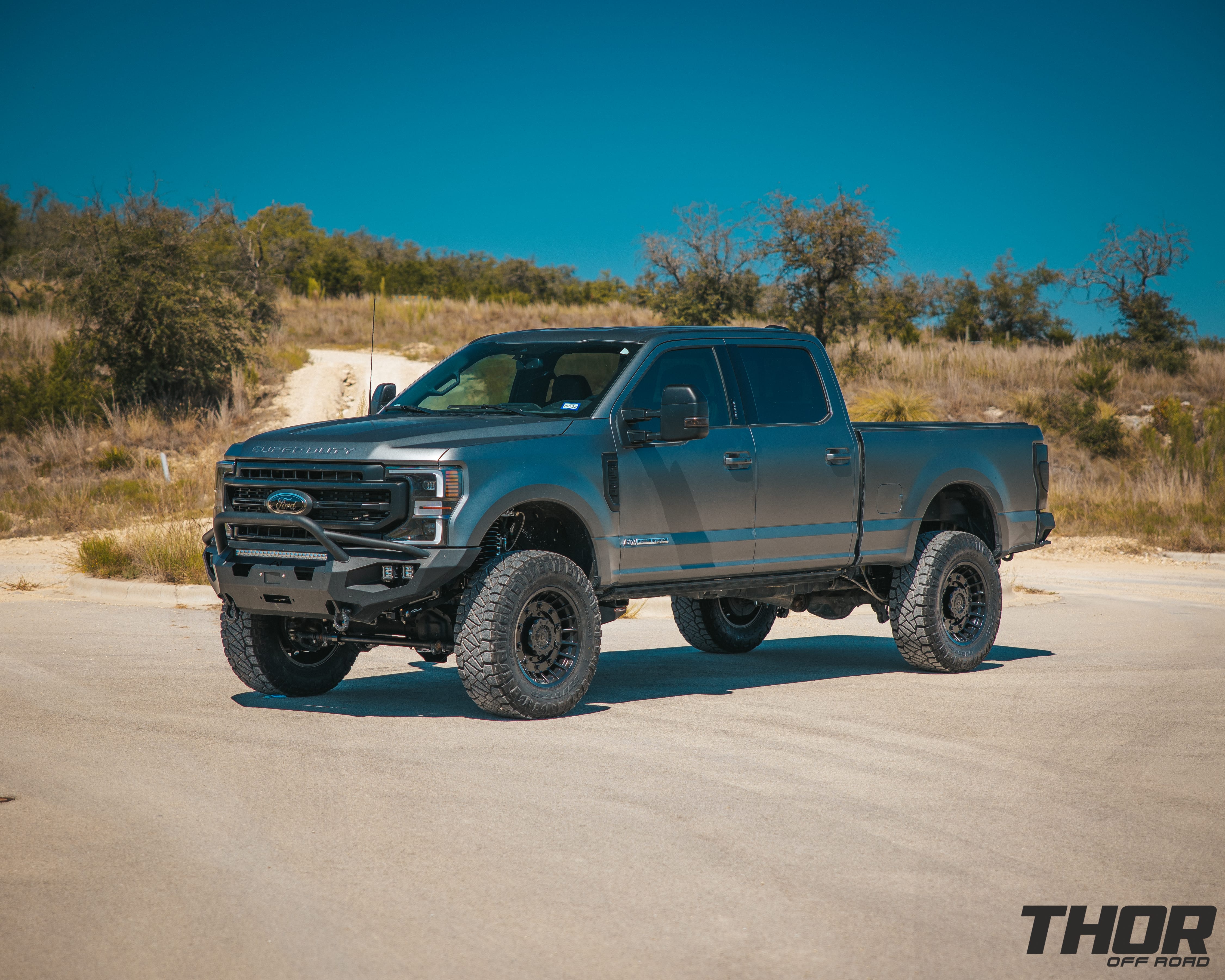 2022 Ford F-250 Super Duty Lariat in Grey with Carli 5.5" Backcountry Suspension Kit, Carli High Mount Steering Stabilizer, Carli Low Mount Steering Stabilizer, Carli Radius Arms, Carli Torsion Sway Bar, Carli Full Rear Spring Replacement, Carli Long Travel Air Bags, 20x10" Miltia Wheels, AMP Research Steps, Retrax Pro Bed Cover, Fab Four Matrix Pre-Runner Front Bumper, Go Rhino BR20.5 Rear Bumper, Rigid D Series Flood Lights