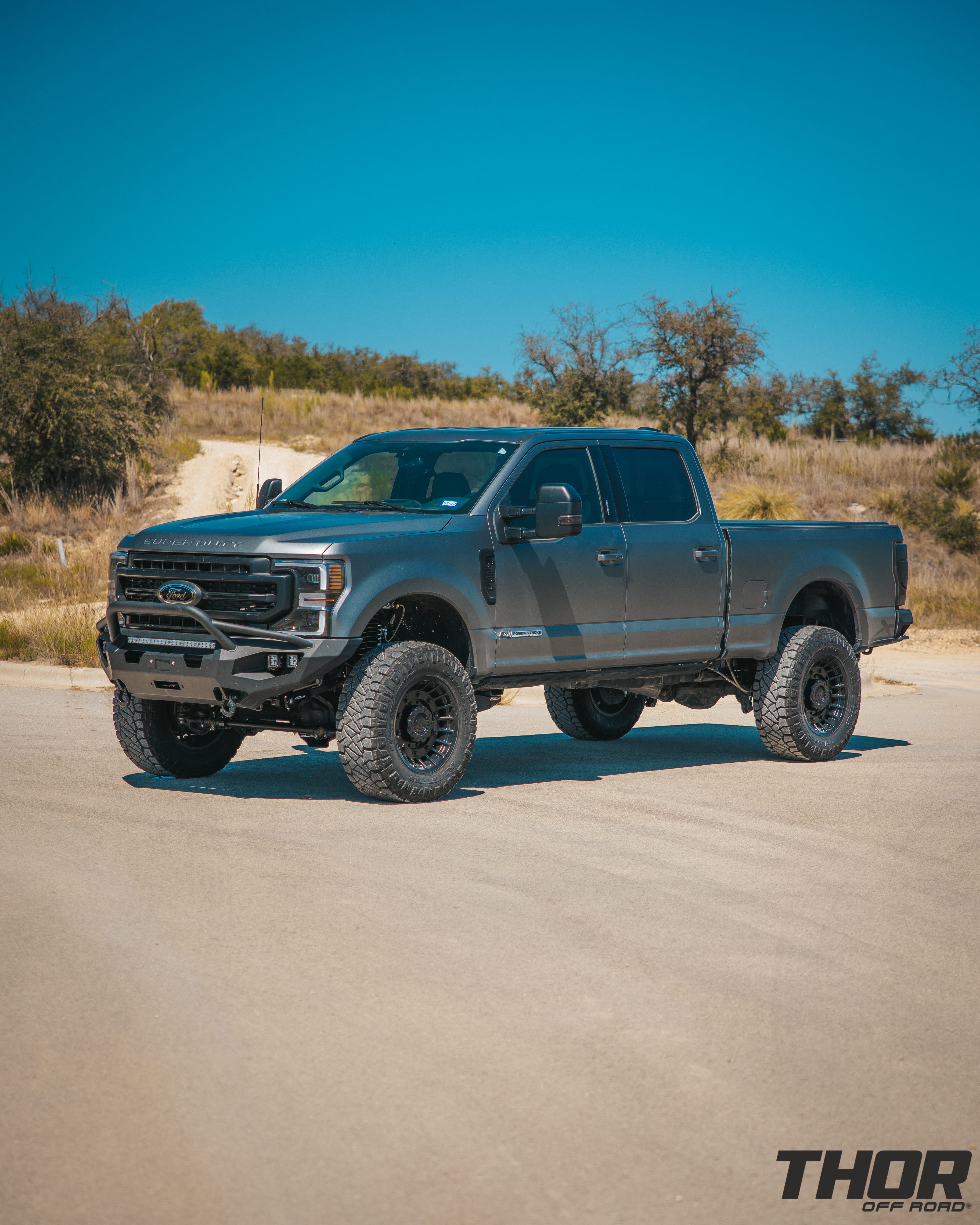 2022 Ford F-250 Super Duty Lariat in Grey with Carli 5.5" Backcountry Suspension Kit, Carli High Mount Steering Stabilizer, Carli Low Mount Steering Stabilizer, Carli Radius Arms, Carli Torsion Sway Bar, Carli Full Rear Spring Replacement, Carli Long Travel Air Bags, 20x10" Miltia Wheels, AMP Research Steps, Retrax Pro Bed Cover, Fab Four Matrix Pre-Runner Front Bumper, Go Rhino BR20.5 Rear Bumper, Rigid D Series Flood Lights