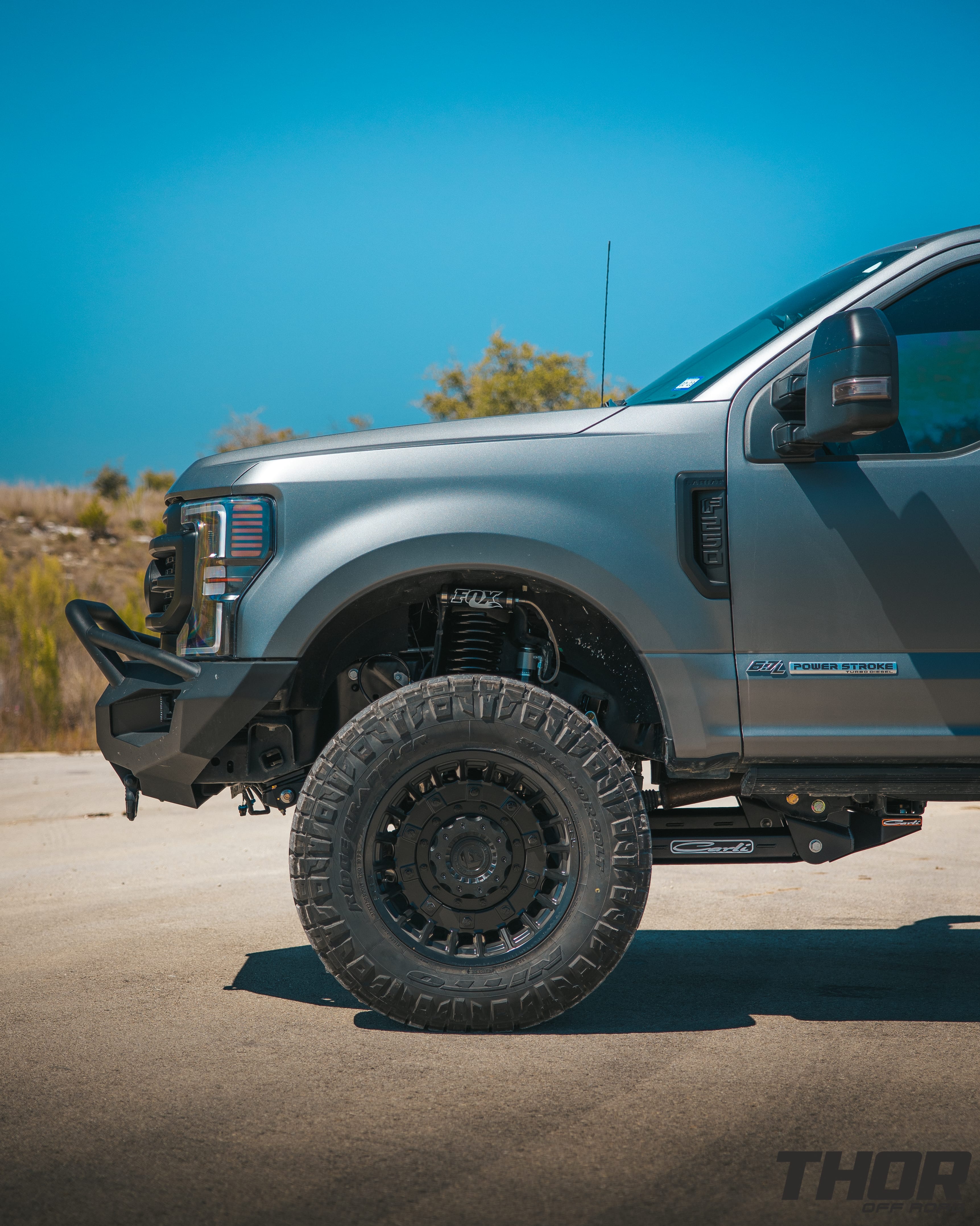 2022 Ford F-250 Super Duty Lariat in Grey with Carli 5.5" Backcountry Suspension Kit, Carli High Mount Steering Stabilizer, Carli Low Mount Steering Stabilizer, Carli Radius Arms, Carli Torsion Sway Bar, Carli Full Rear Spring Replacement, Carli Long Travel Air Bags, 20x10" Miltia Wheels, AMP Research Steps, Retrax Pro Bed Cover, Fab Four Matrix Pre-Runner Front Bumper, Go Rhino BR20.5 Rear Bumper, Rigid D Series Flood Lights