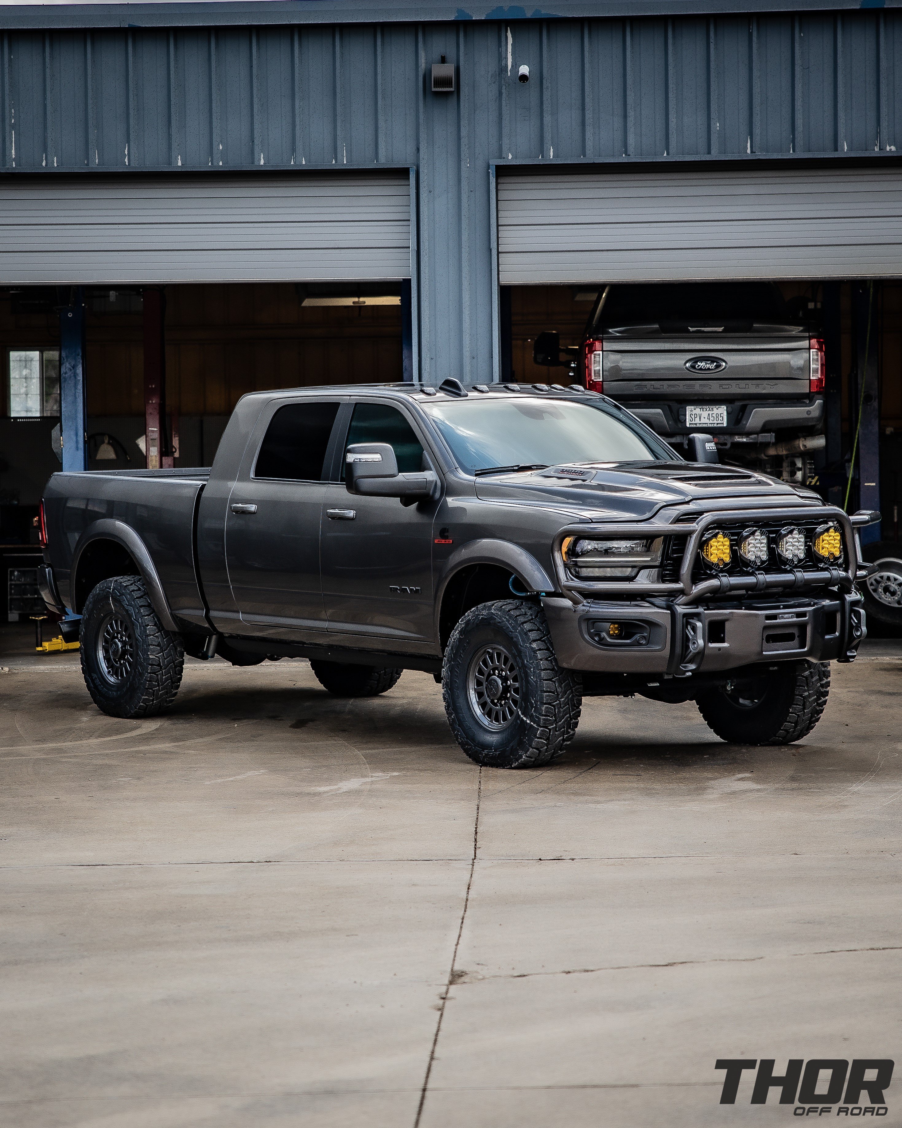 2023 RAM 3500 Limited in Grey with Carli 3.25" Pintop Suspension System, Carli Leaf Springs, Carli Torsion Sway Bar, Carli High Mount Steering Stabilizer, Carli Low Mount Steering Stabilizer, Carli Fabricated Radius Arms, AEV HD Low Tube Front Bumper, AEV 17"x8.5" Salta Onyx Wheels, 37x12.50R17 Toyo RT Tires, Smart Cap, Decked System, LP9 Clear Pro Driving Combo Lights, LP9 Amber Pro Driving Combo Lights, Baja Design Flush Mount Squadron Lights, Baja Design Fog Light Pocket Kit, BW Tow and Stow Hitch, Fender Flares, Titan XL 50 Gallon Fuel Tank, Valentine V2 Blend Mount, Magnaflow Exhaust