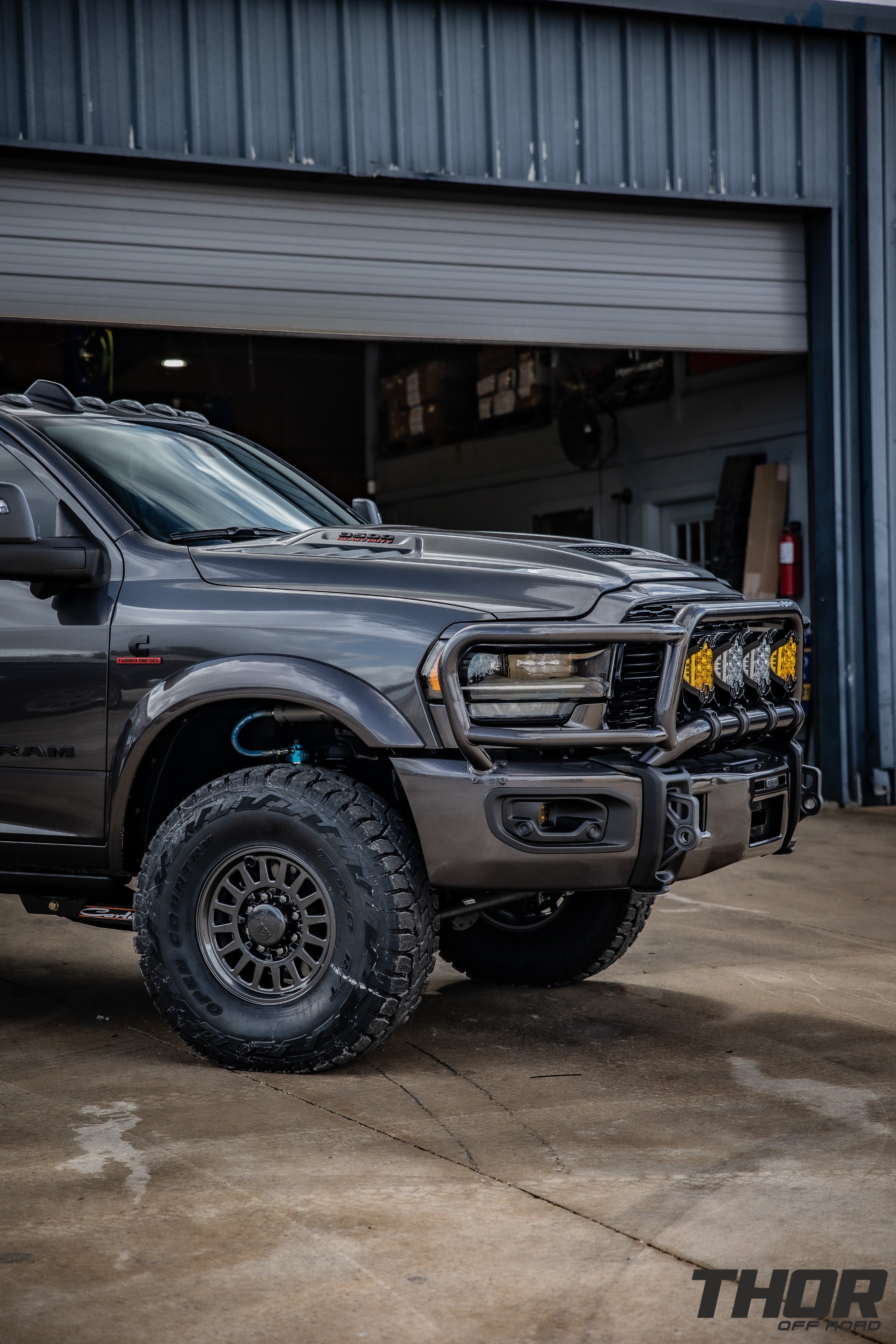 2023 RAM 3500 Limited in Grey with Carli 3.25" Pintop Suspension System, Carli Leaf Springs, Carli Torsion Sway Bar, Carli High Mount Steering Stabilizer, Carli Low Mount Steering Stabilizer, Carli Fabricated Radius Arms, AEV HD Low Tube Front Bumper, AEV 17"x8.5" Salta Onyx Wheels, 37x12.50R17 Toyo RT Tires, Smart Cap, Decked System, LP9 Clear Pro Driving Combo Lights, LP9 Amber Pro Driving Combo Lights, Baja Design Flush Mount Squadron Lights, Baja Design Fog Light Pocket Kit, BW Tow and Stow Hitch, Fender Flares, Titan XL 50 Gallon Fuel Tank, Valentine V2 Blend Mount, Magnaflow Exhaust