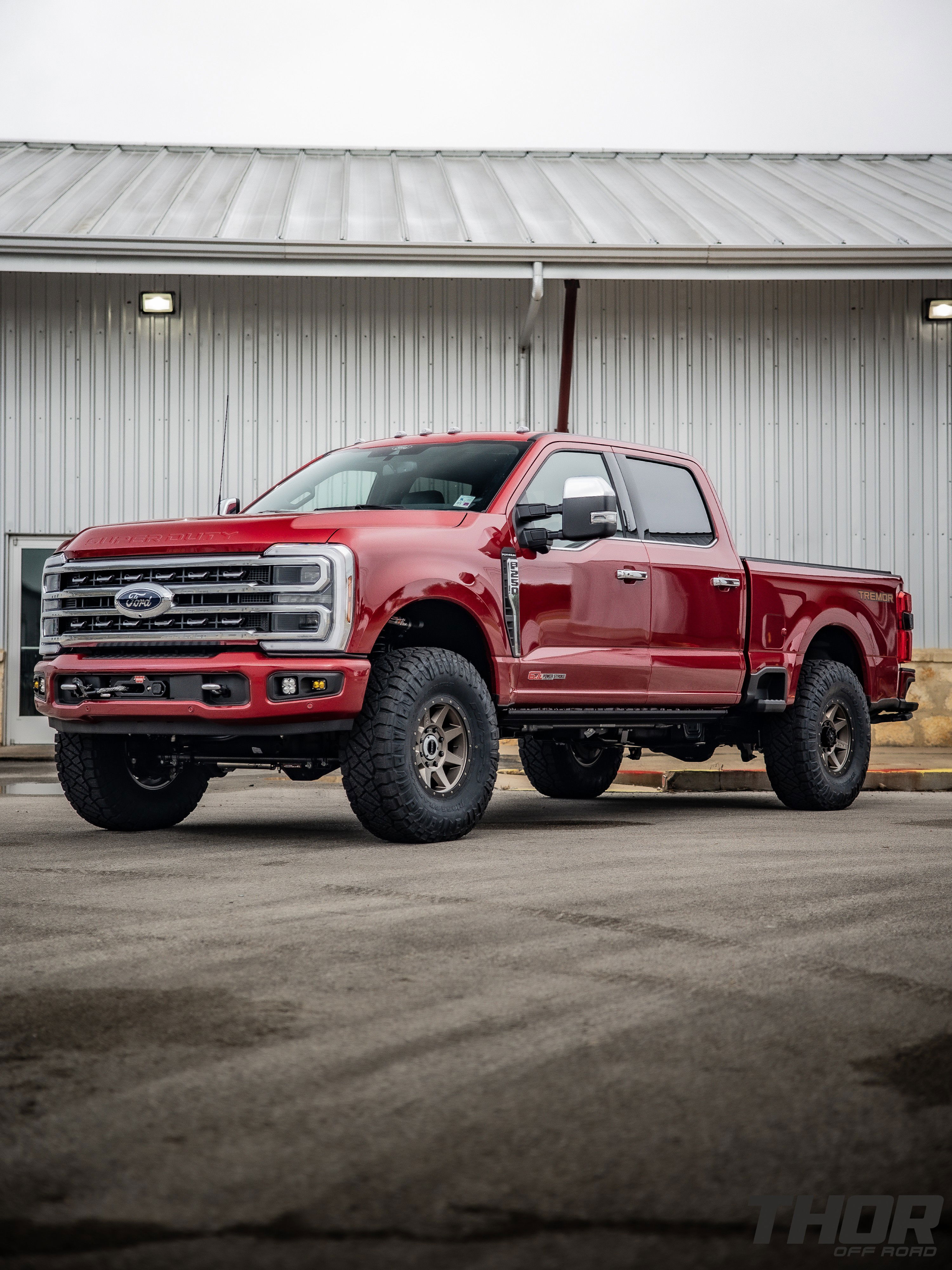 2024 Ford F-250 Super Duty Platinum in Red with Carli E-Venture 3.5" Suspension Kit, Carli 3.5" Fabricated Radius Arms, Carli 3.5" Full Rear Spring Replacement, Carli Low Mount Steering Stabilizer, Carli High Mount Steering Stabilizer, Carli Torsion Sway Bar, Carli Trophy Hitch, Raceline Clutch 17x9" Wheels, Nitto Ridge Grappler 37x12.50R17 Tires, BMC Fog Light Kit, Baja Designs S2 Auxillary Light Pods, Baja Designs Squadron Sport Light Pods, Baja Designs S2 Sport Single Flush Mount, CJC Lockout Bracket, Pro Eagle 3 Ton Kratos Off Road Jack, AMP Research Power Steps