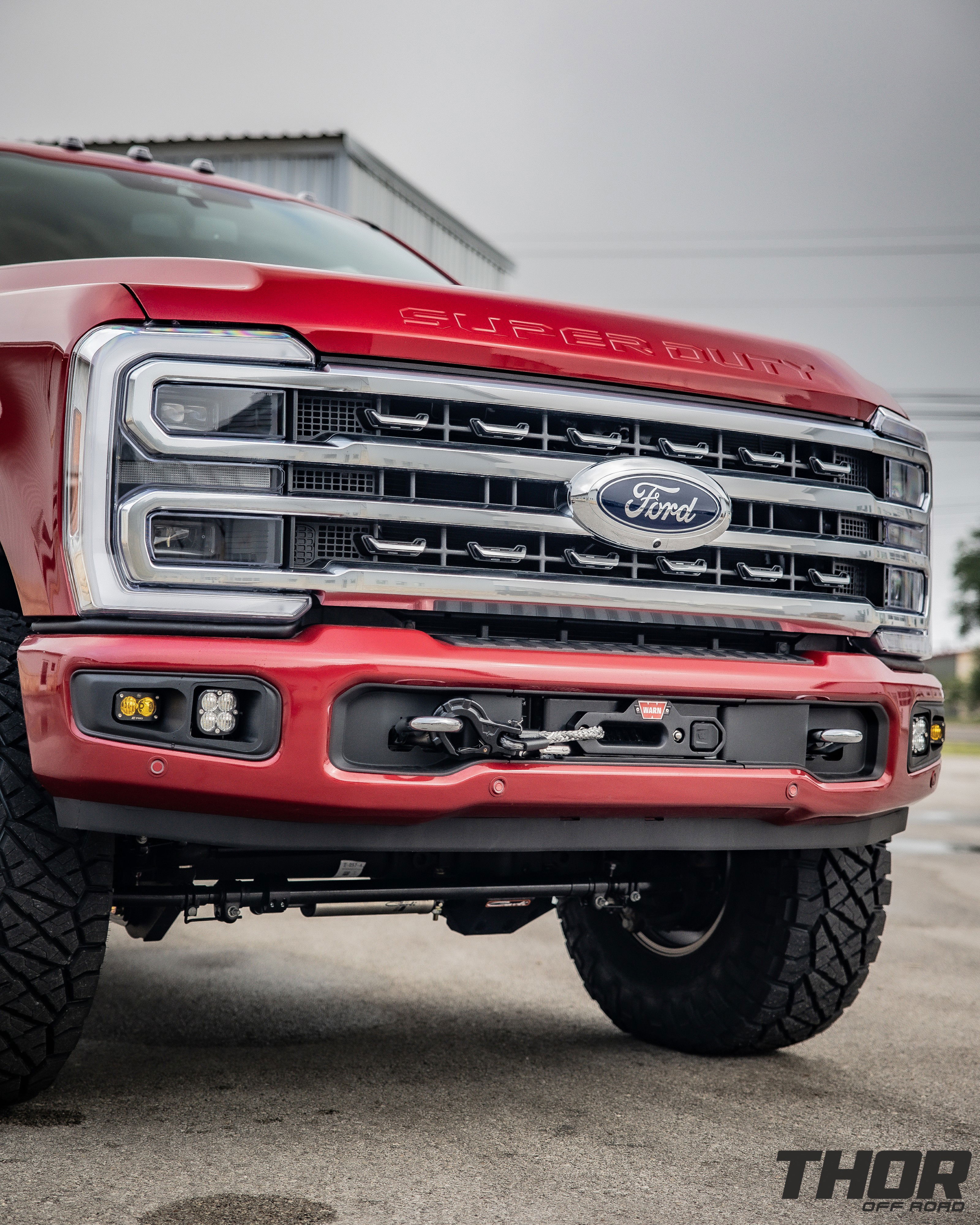 2024 Ford F-250 Super Duty Platinum in Red with Carli E-Venture 3.5" Suspension Kit, Carli 3.5" Fabricated Radius Arms, Carli 3.5" Full Rear Spring Replacement, Carli Low Mount Steering Stabilizer, Carli High Mount Steering Stabilizer, Carli Torsion Sway Bar, Carli Trophy Hitch, Raceline Clutch 17x9" Wheels, Nitto Ridge Grappler 37x12.50R17 Tires, BMC Fog Light Kit, Baja Designs S2 Auxillary Light Pods, Baja Designs Squadron Sport Light Pods, Baja Designs S2 Sport Single Flush Mount, CJC Lockout Bracket, Pro Eagle 3 Ton Kratos Off Road Jack, AMP Research Power Steps