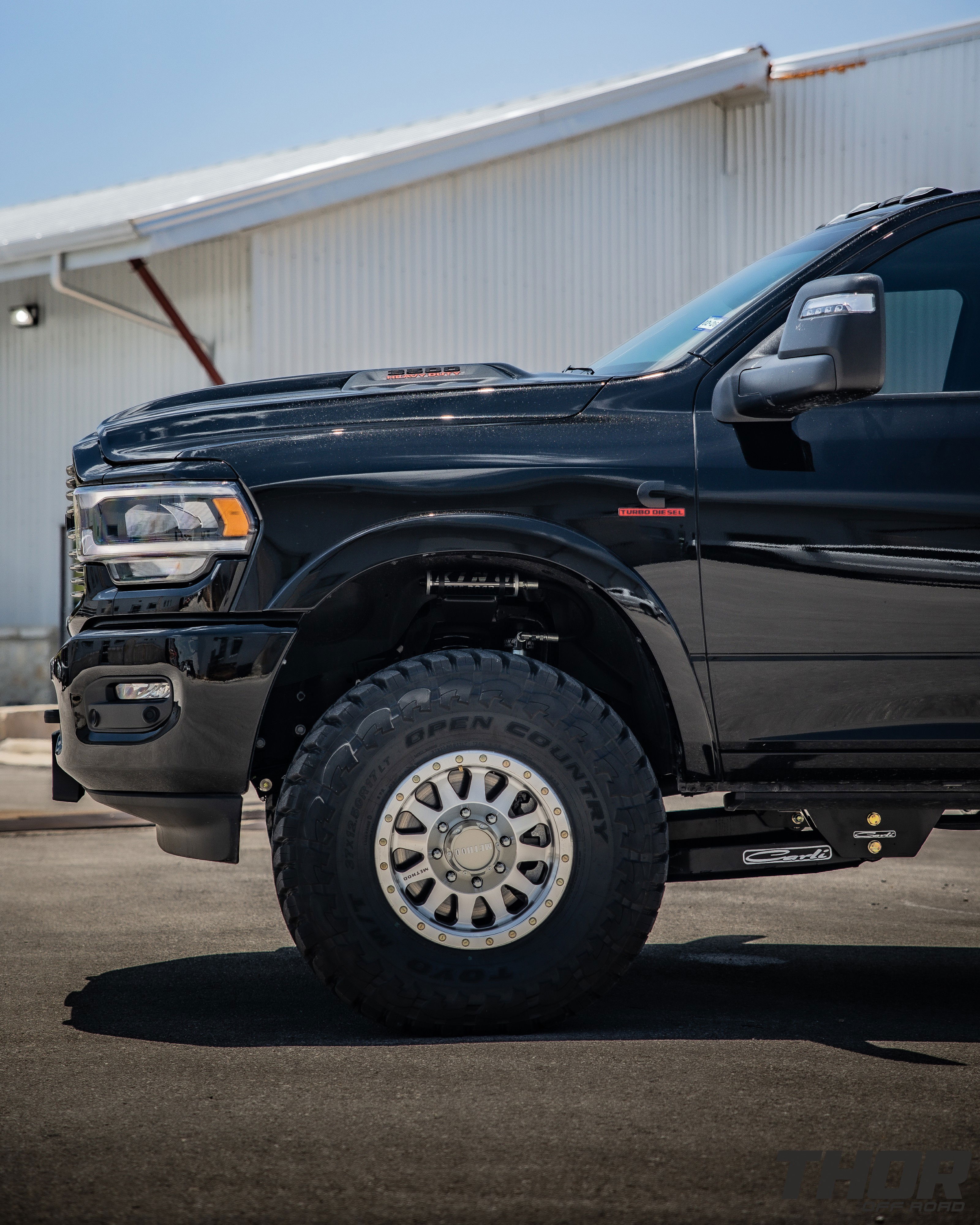 2024 RAM 3500 in Black with 3.25" Carli King Pintop Suspension, Carli Radius Drop Arm, Carli Low Mount Steering Stabilizer, Carli High Mount Steering Stabilizer, Carli Progressive Leaf Spring Kit, Carli Torsion Sway Bar, OEM Fender Flares, BW Tow and Stow