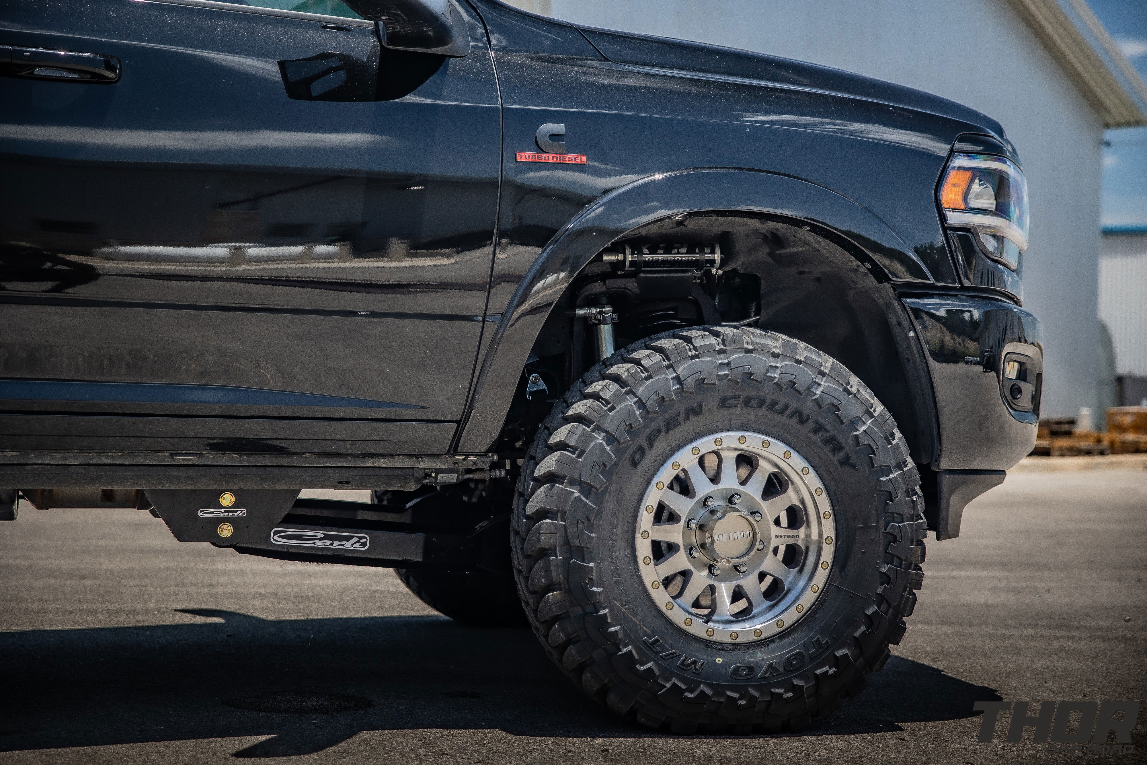 2024 RAM 3500 in Black with 3.25" Carli King Pintop Suspension, Carli Radius Drop Arm, Carli Low Mount Steering Stabilizer, Carli High Mount Steering Stabilizer, Carli Progressive Leaf Spring Kit, Carli Torsion Sway Bar, OEM Fender Flares, BW Tow and Stow