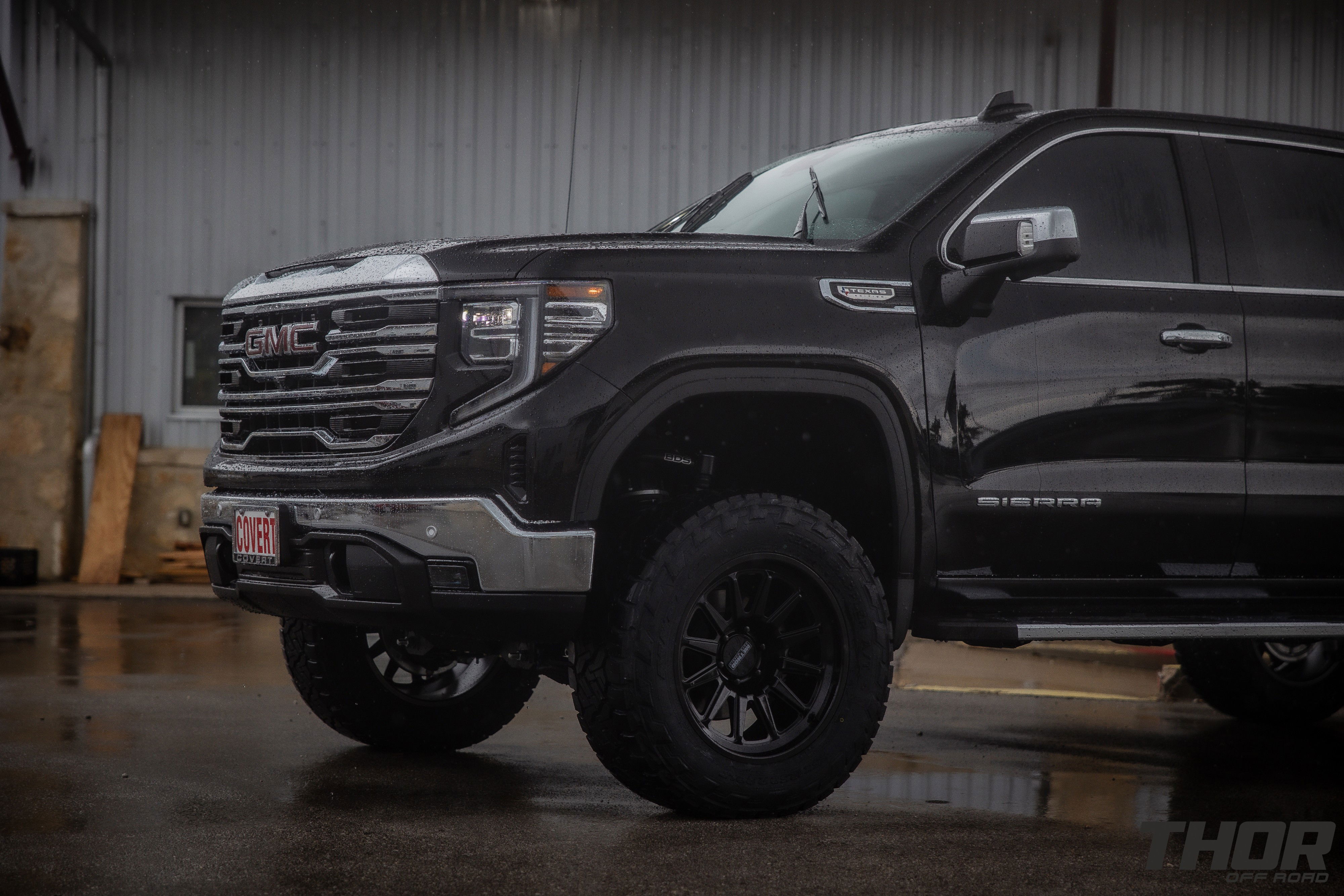 2024 GMC Sierra 1500 SLT in Black with 6" Lift Kit, Nitto Recon Grappler A/T 35x12.50R20 Tires, Method MR323 Gloss Black 20x10" Wheels, BakFlip Tonneau Cover