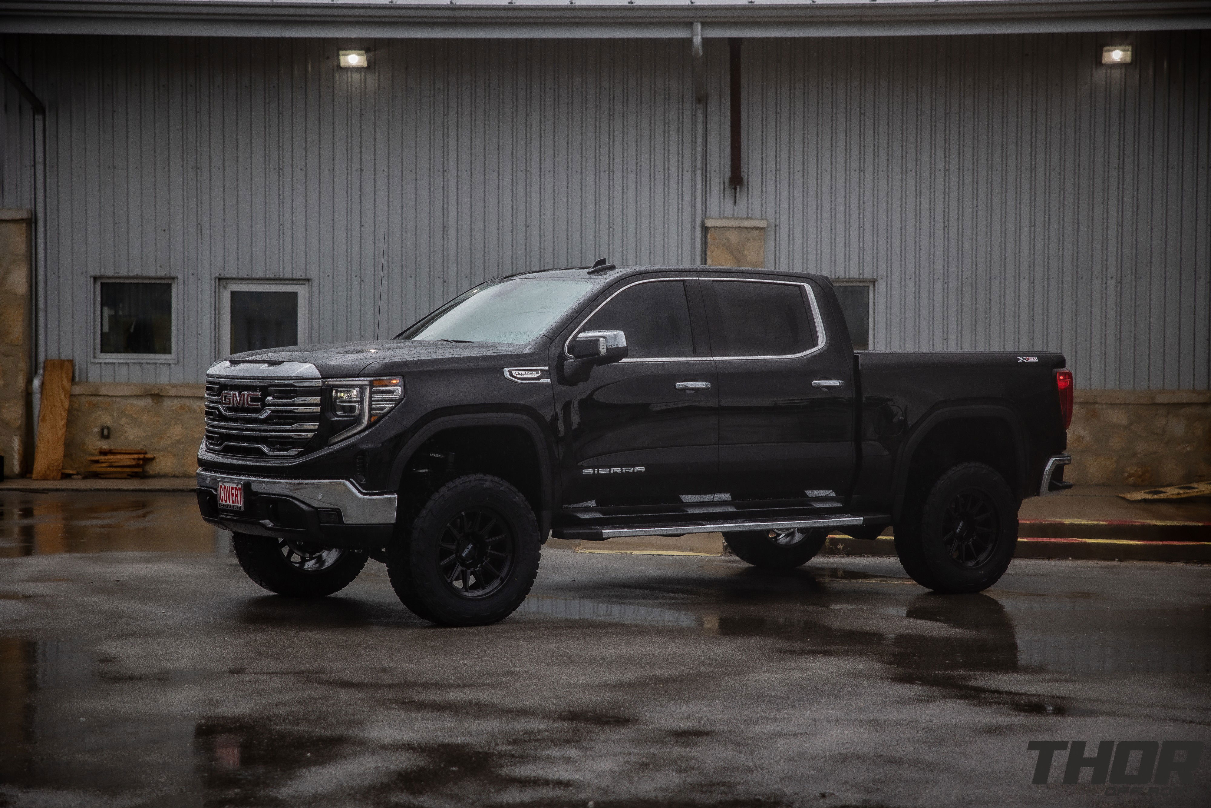 2024 GMC Sierra 1500 SLT in Black with 6" Lift Kit, Nitto Recon Grappler A/T 35x12.50R20 Tires, Method MR323 Gloss Black 20x10" Wheels, BakFlip Tonneau Cover