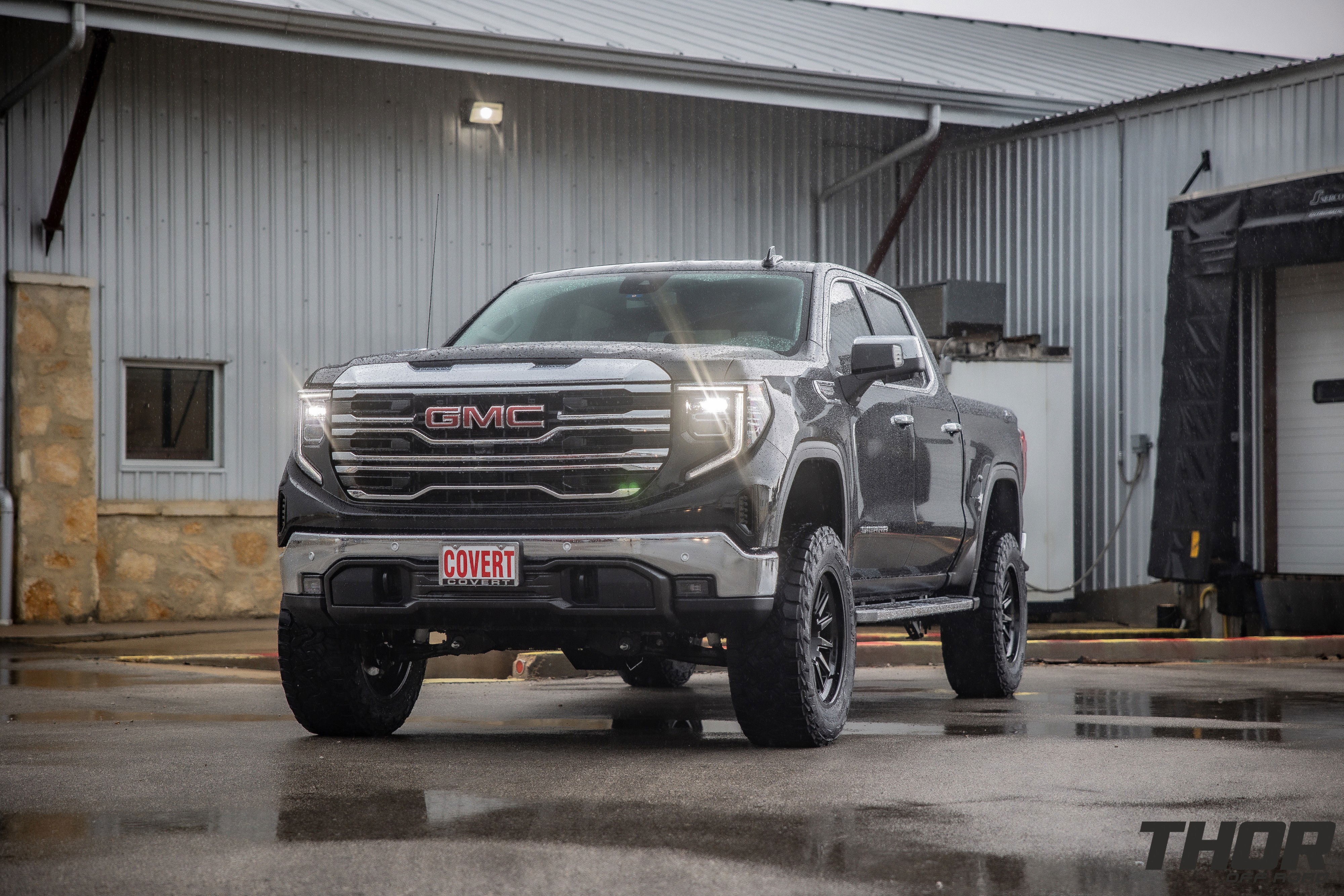 2024 GMC Sierra 1500 SLT in Black with 6" Lift Kit, Nitto Recon Grappler A/T 35x12.50R20 Tires, Method MR323 Gloss Black 20x10" Wheels, BakFlip Tonneau Cover