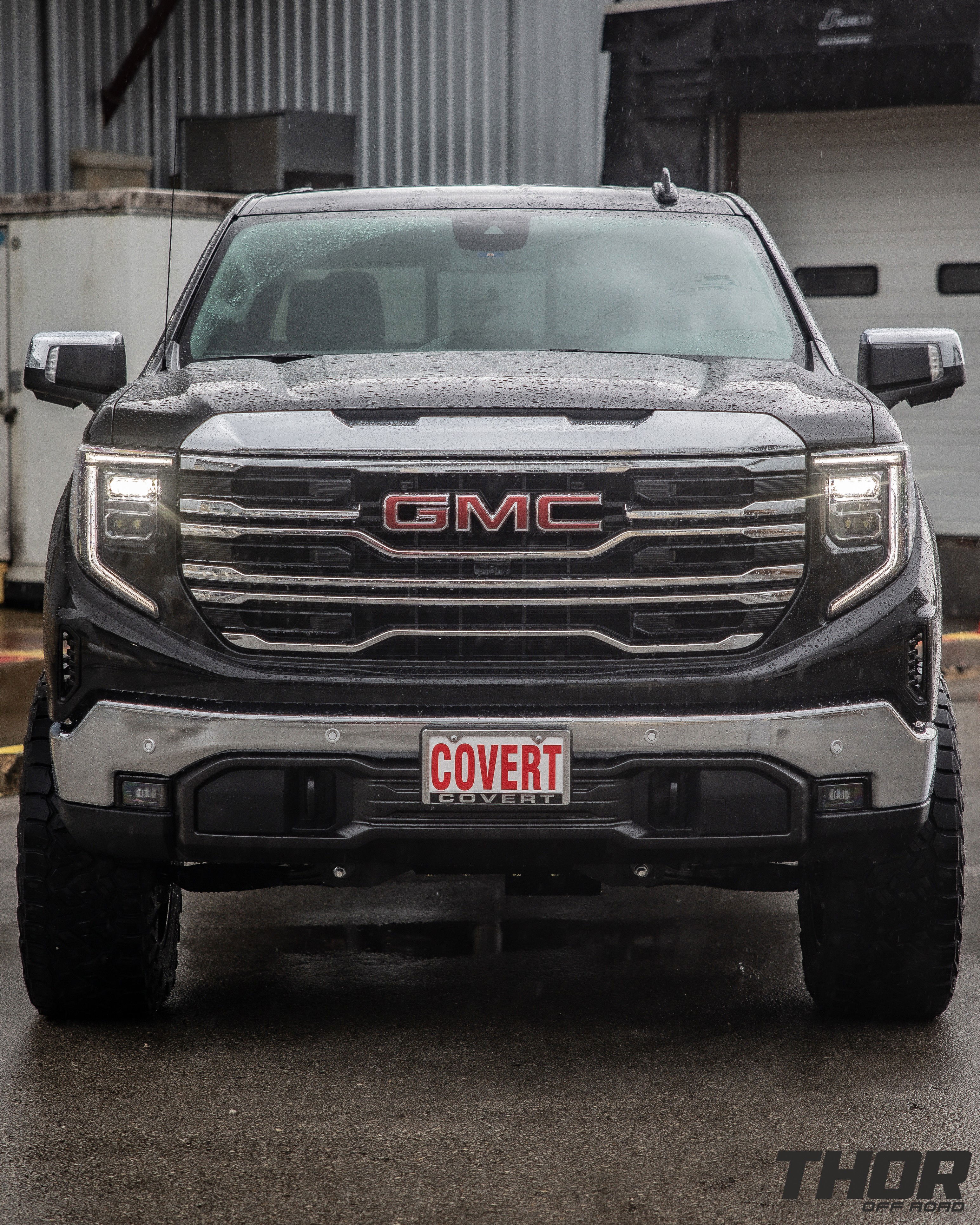 2024 GMC Sierra 1500 SLT in Black with 6" Lift Kit, Nitto Recon Grappler A/T 35x12.50R20 Tires, Method MR323 Gloss Black 20x10" Wheels, BakFlip Tonneau Cover