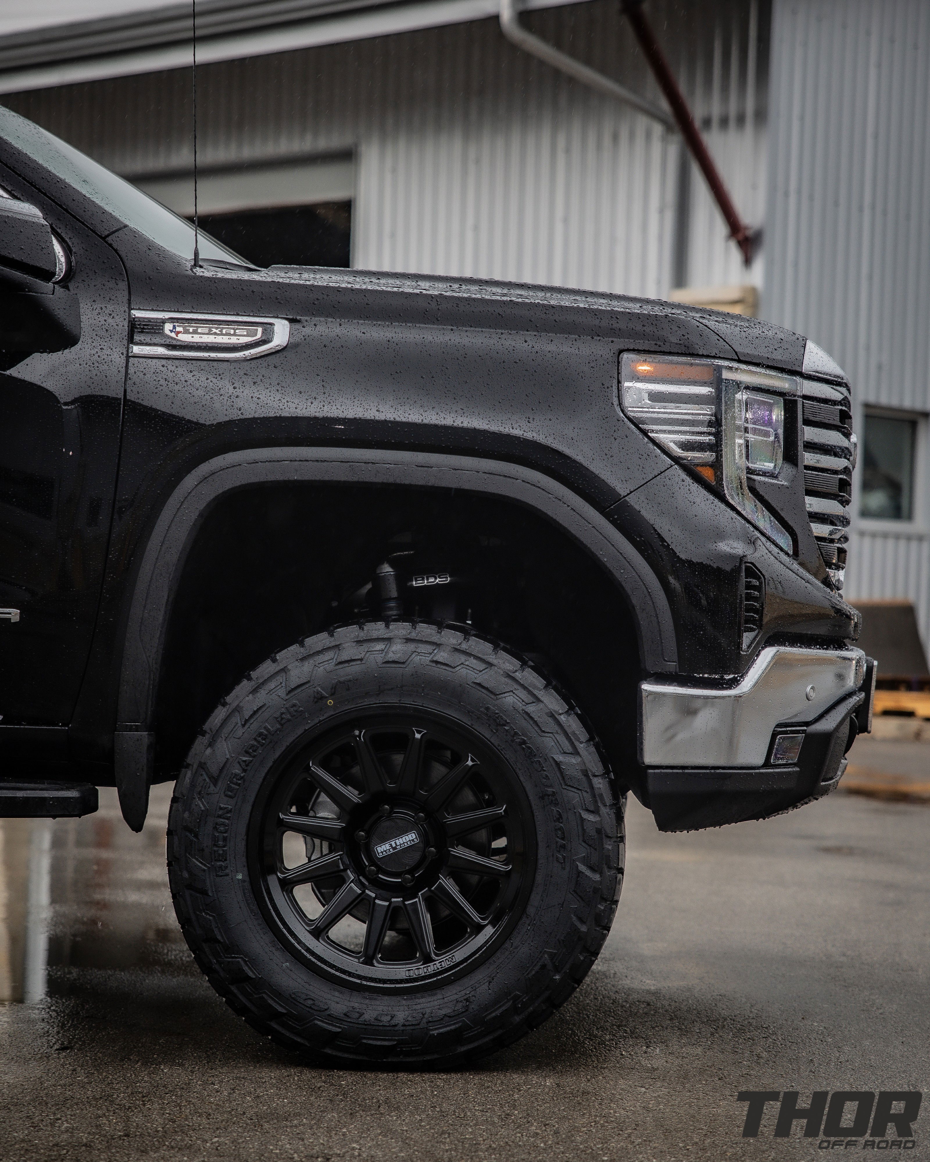 2024 GMC Sierra 1500 SLT in Black with 6" Lift Kit, Nitto Recon Grappler A/T 35x12.50R20 Tires, Method MR323 Gloss Black 20x10" Wheels, BakFlip Tonneau Cover