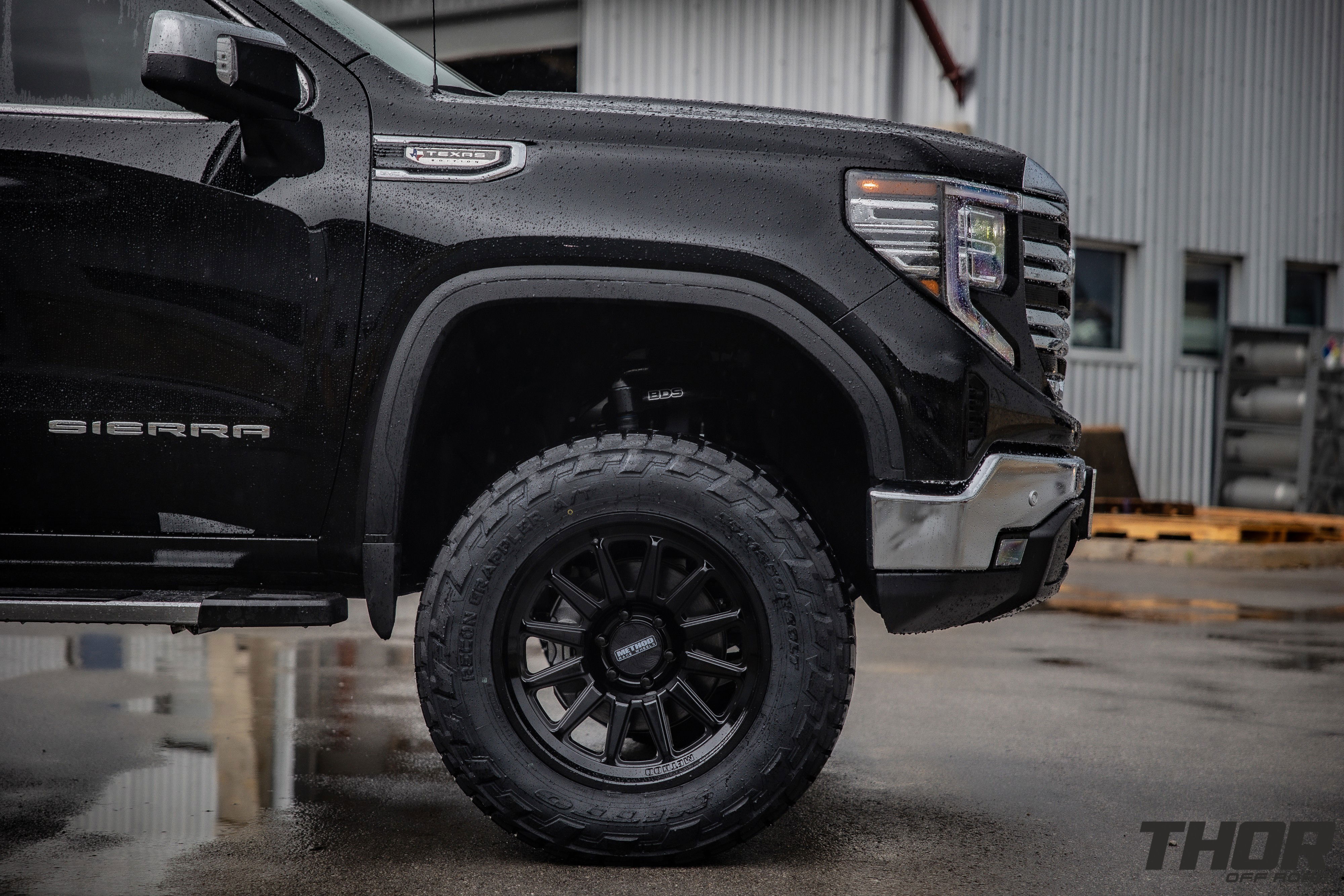 2024 GMC Sierra 1500 SLT in Black with 6" Lift Kit, Nitto Recon Grappler A/T 35x12.50R20 Tires, Method MR323 Gloss Black 20x10" Wheels, BakFlip Tonneau Cover