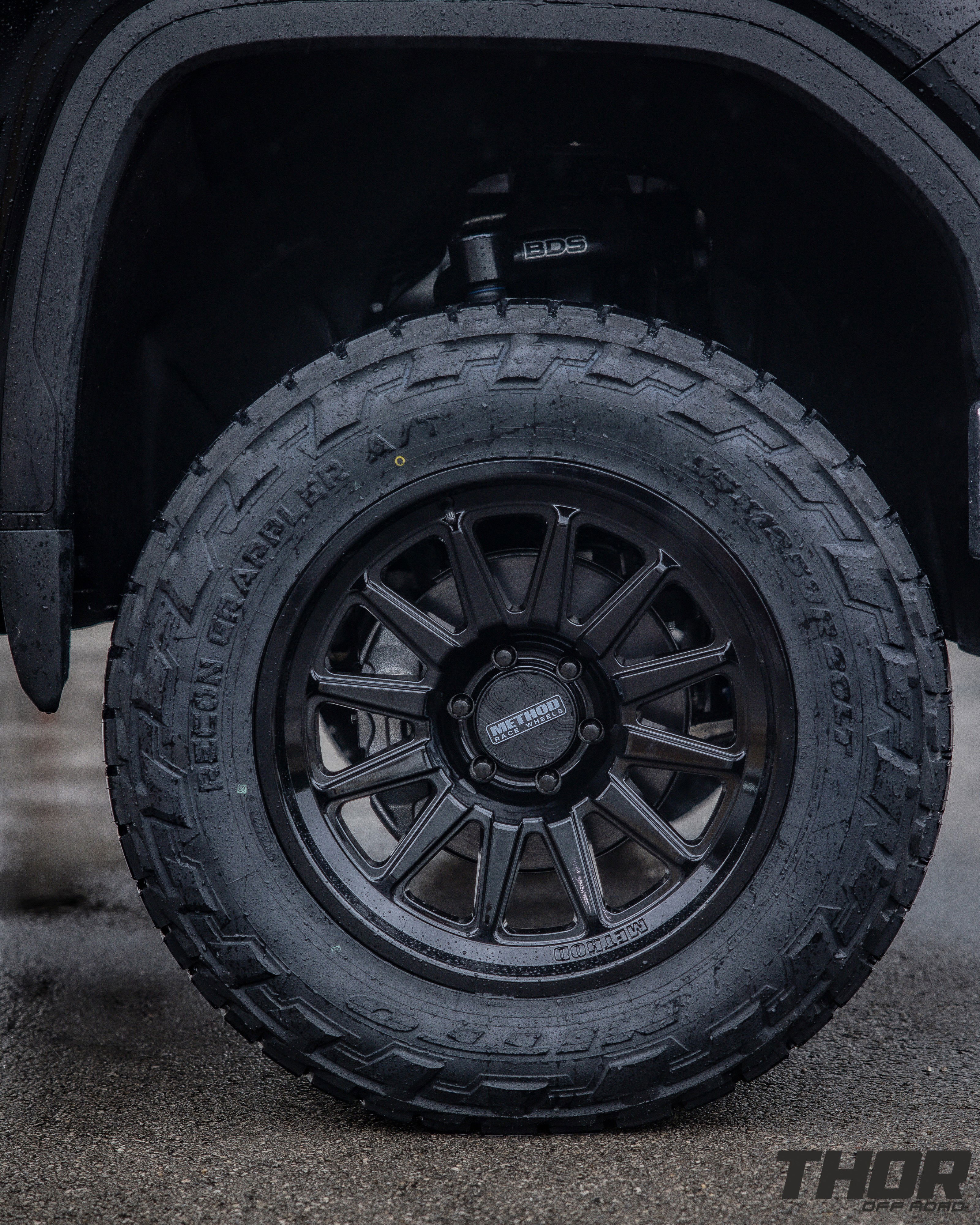 2024 GMC Sierra 1500 SLT in Black with 6" Lift Kit, Nitto Recon Grappler A/T 35x12.50R20 Tires, Method MR323 Gloss Black 20x10" Wheels, BakFlip Tonneau Cover