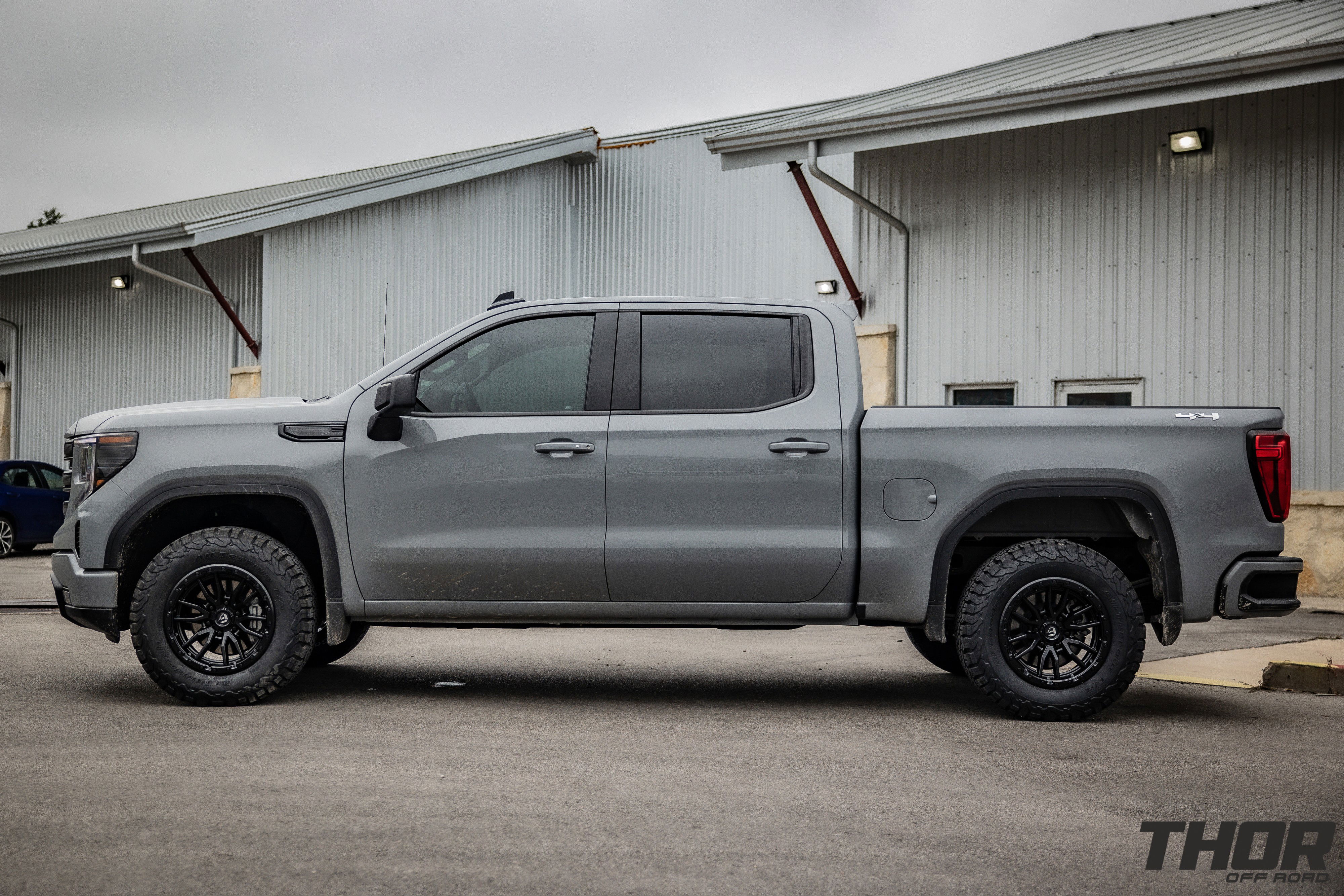 2024 GMC Sierra 1500 in Grey with Rough Country 2" Leveling Kit, BF Goodrich A/T KO2 35x12.50R20 Tires, Fuel Rebel Matte Black 18x9" Wheels, Spray in Bedliner, BakFlip Tonneau Cover