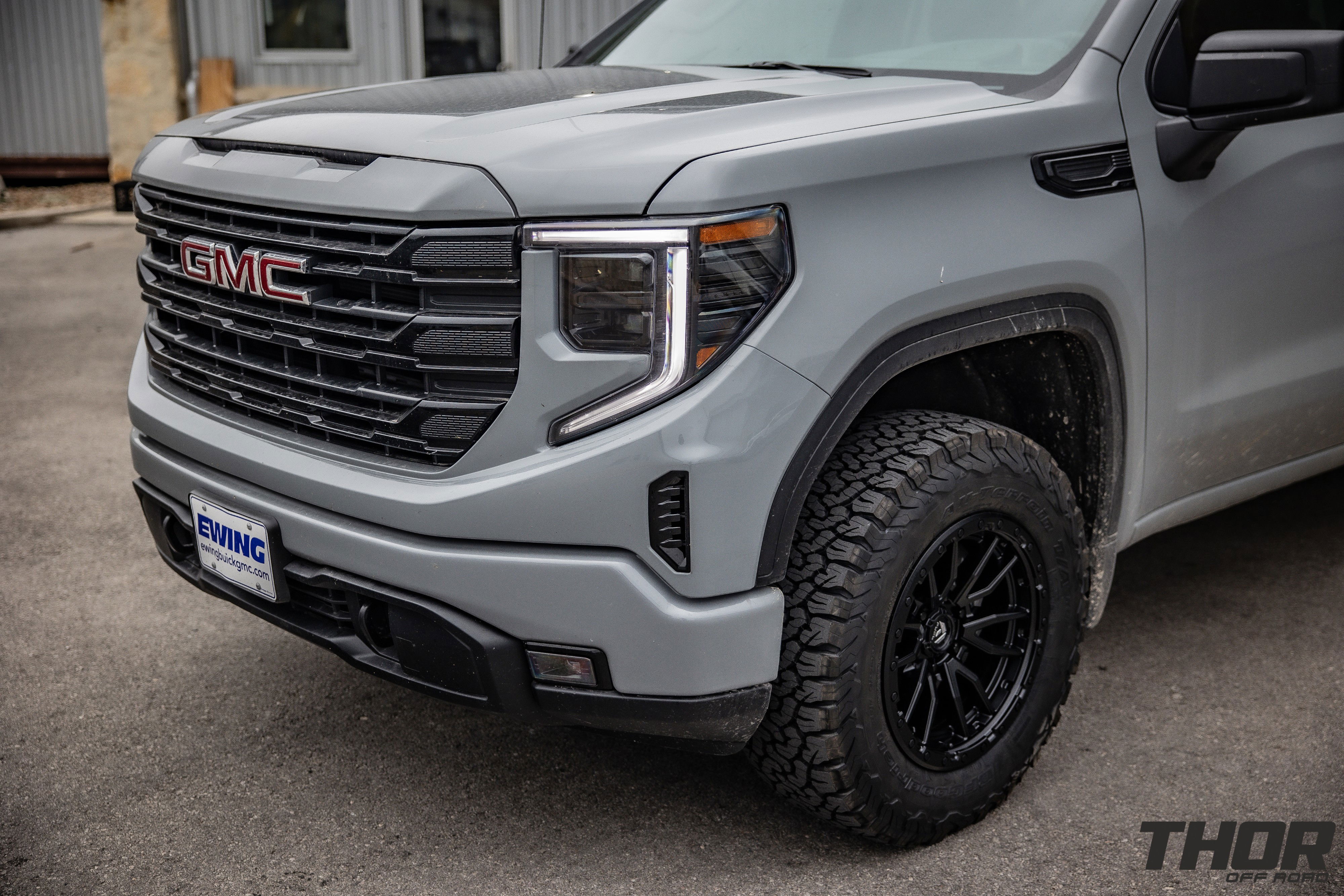 2024 GMC Sierra 1500 in Grey with Rough Country 2" Leveling Kit, BF Goodrich A/T KO2 35x12.50R20 Tires, Fuel Rebel Matte Black 18x9" Wheels, Spray in Bedliner, BakFlip Tonneau Cover