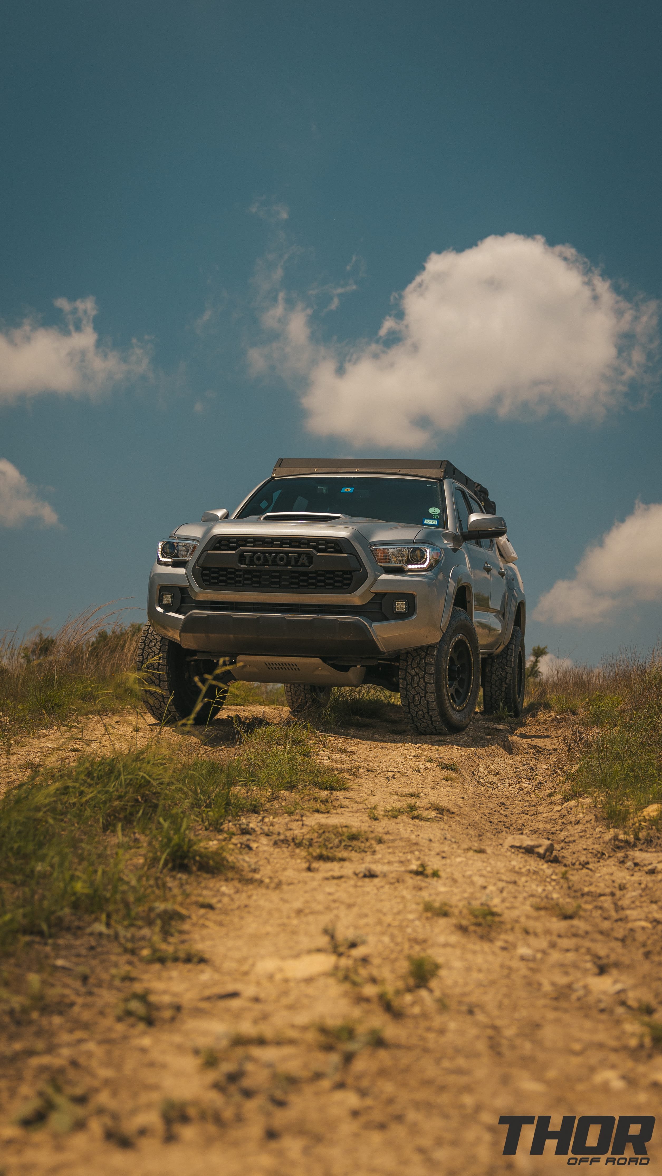 2016 Toyota Tacoma TRD Sport in Silver with 3" Icon Dynamics Stage 8 Suspension Kit, 285/70R17 Toyo Tires, 17" Method 305NV Wheels, CBI Roof Rack, Smitty Built Tent and Cover, RotoPax and MaxxTrax, Rigid Fog Light Kit