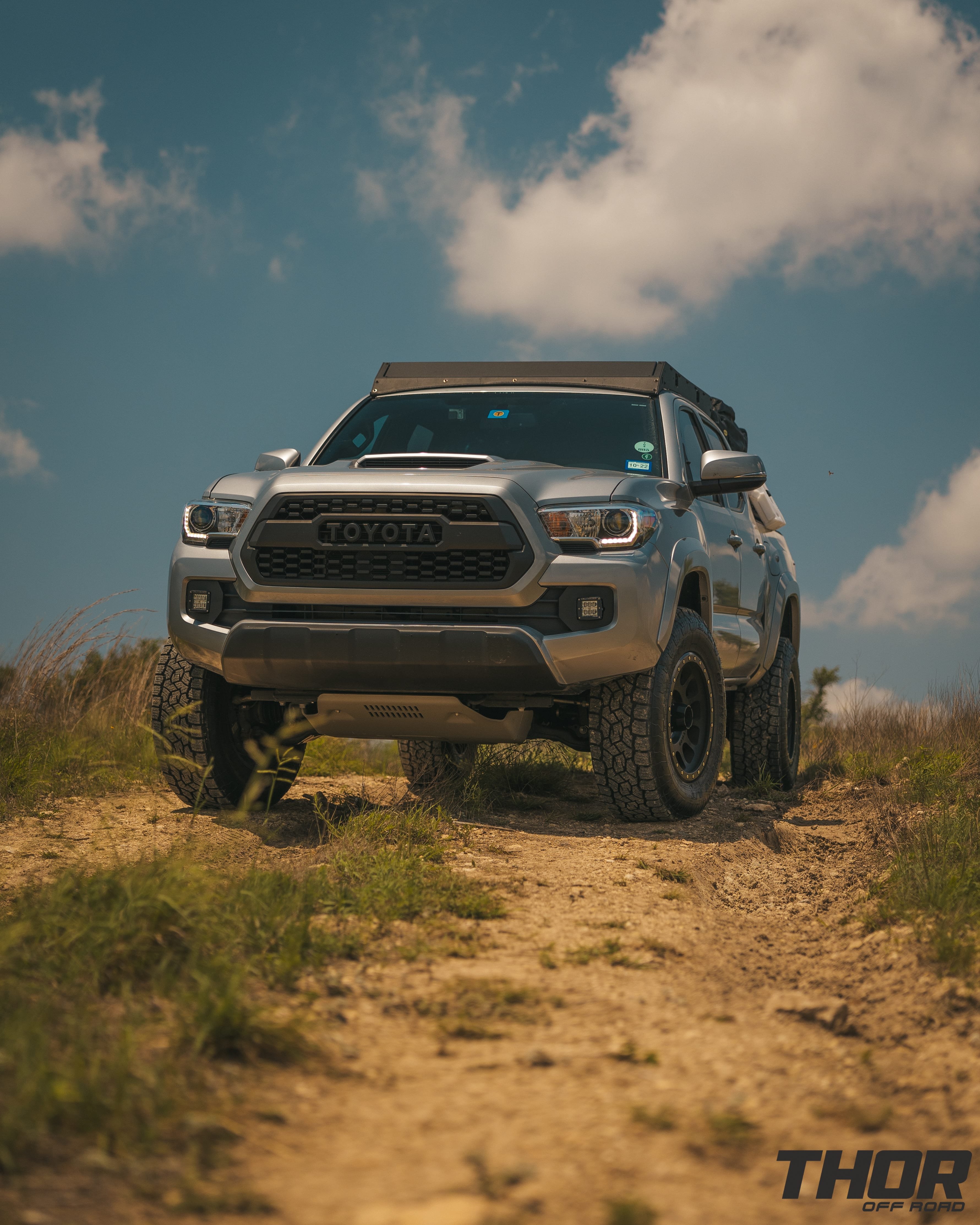 2016 Toyota Tacoma TRD Sport in Silver with 3" Icon Dynamics Stage 8 Suspension Kit, 285/70R17 Toyo Tires, 17" Method 305NV Wheels, CBI Roof Rack, Smitty Built Tent and Cover, RotoPax and MaxxTrax, Rigid Fog Light Kit