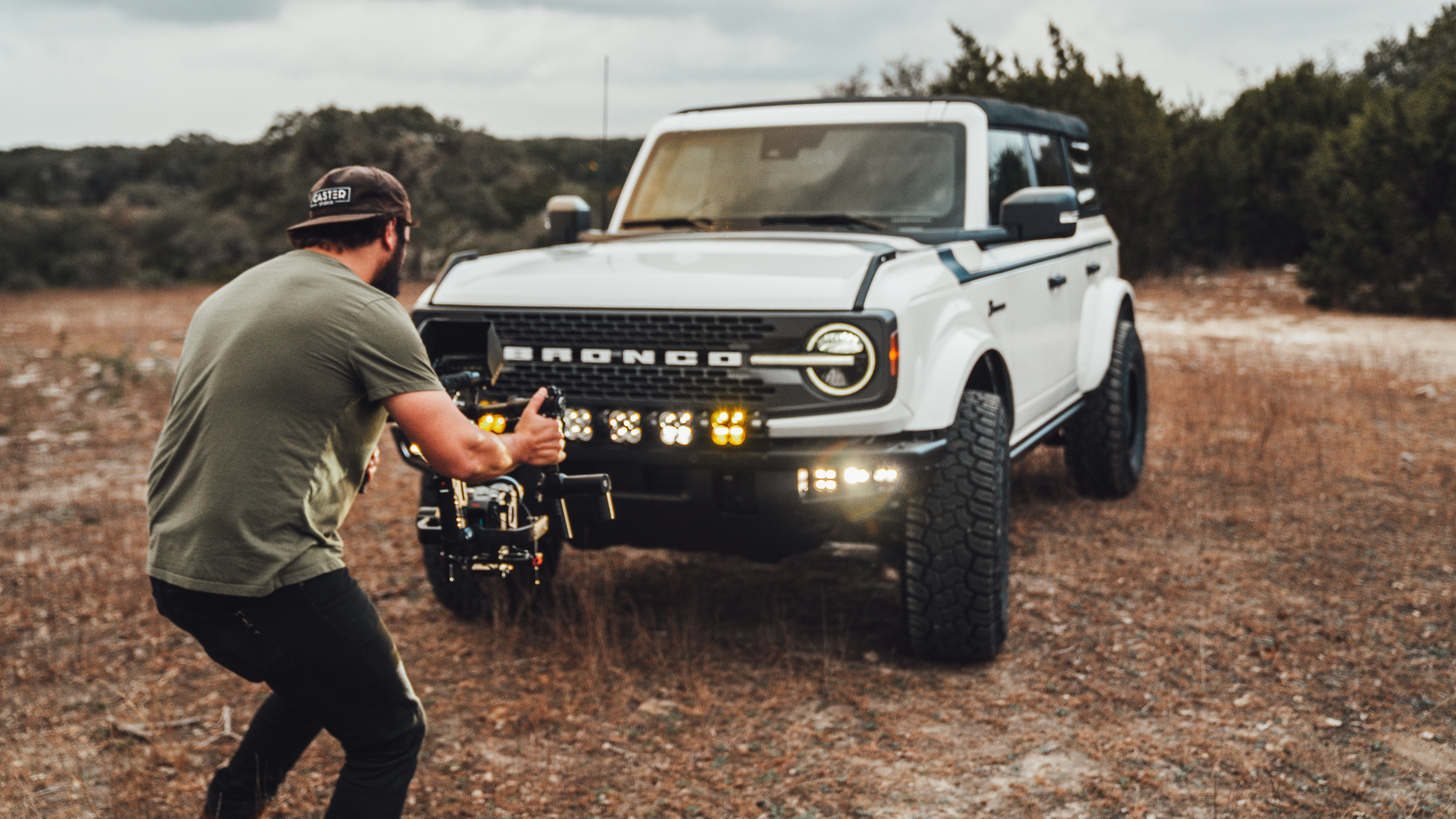 2021 Ford Bronco Badlands in Oxford White with Baja Design Fog Light Pocket Kit, XL Squadron Sport Linkable Lights, 17" Raceline wheels, 35x12.50R17 Yokohama Geolander X-AT Tires, Rough Country Spare Tire Extender, Third Brake Light Relocation Bracket, Paint Matched Fender Flares, Retro Striping, Retro Badges