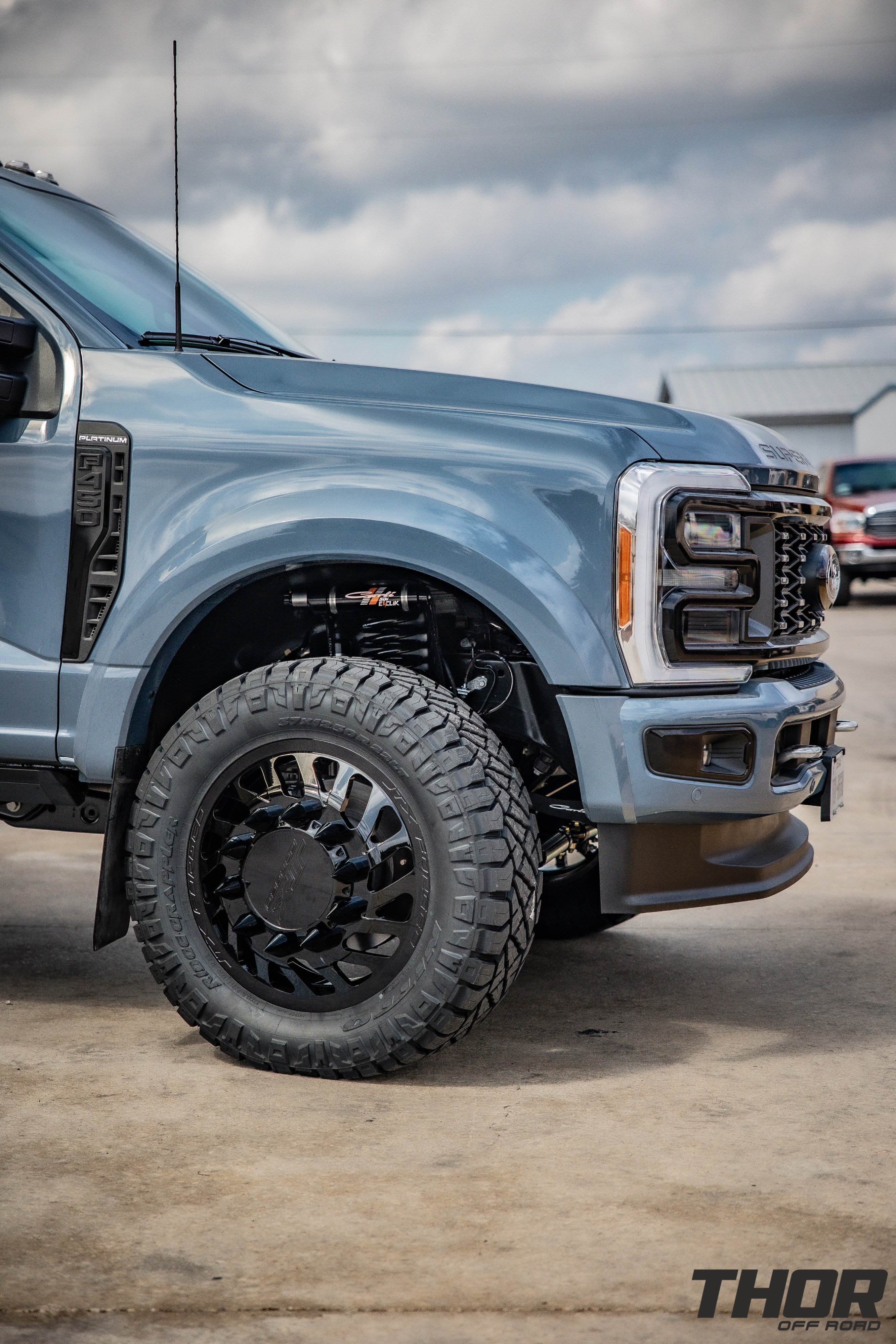 2023 Ford F-450 Super Duty Platinum in Blue with Carli 3.5" E-Venture System, Carli Full Rear Spring Replacement, Carli Torsion Sway Bar, PMF Steering Stabilizer, Carli 3.5" Fabricated Radius Arms, JTX Centerfire 22x8.25" Wheels, 37x12.50R22 Nitto Ridge Grappler Tires, Retrax Pro XR Bed Cover, Spray in Bed Liner, Train Horn, BW Tow and Stow, Curt Hitch Lock