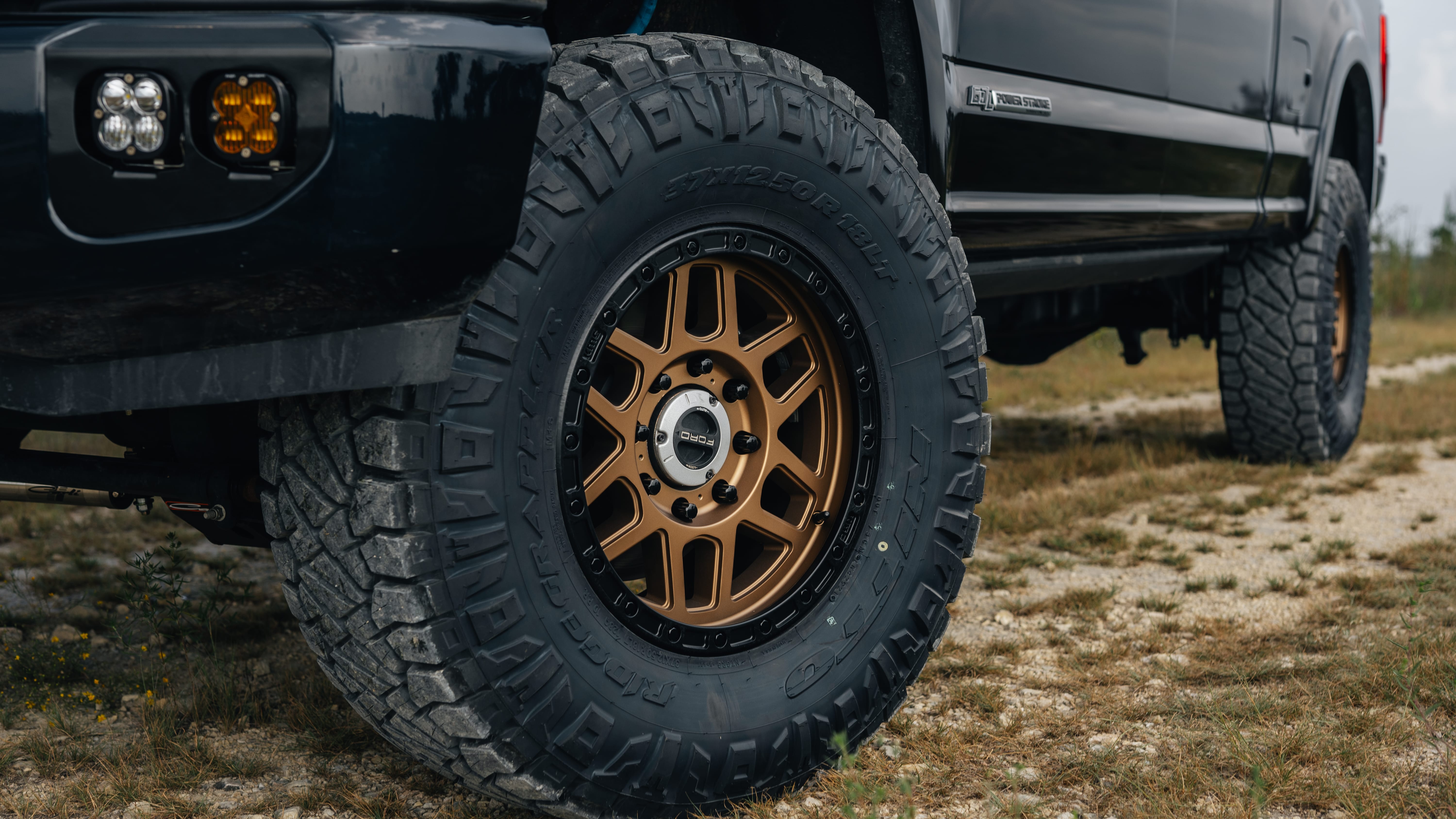 2021 Ford F-250 Super Duty Lariat in Black with Carli 3.5" King Pintop Suspension Kit, Retrax Pro MX Bedcover, 18" KMC Mesa Wheels, AMP Research Steps, Baja Squadron Fog Light Pocket Kit, 37x12.50R18 Ridge Grappler Tires